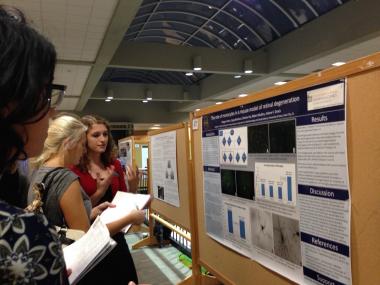Megan explaining her poster to an interested attendee.